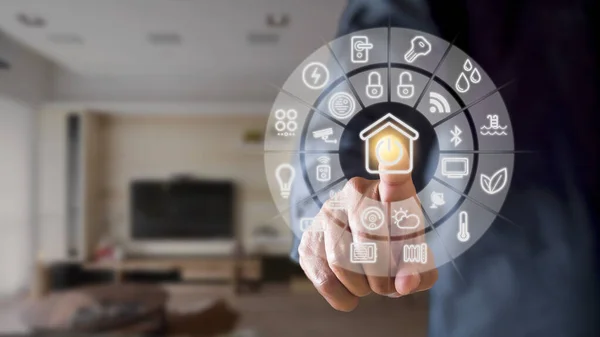 Oturma odasındaki akıllı el işaretli ev arayüzü. Sanal ekranda akıllı ekran ev otomasyon asistanı ve düğmeye basan bir kullanıcı
