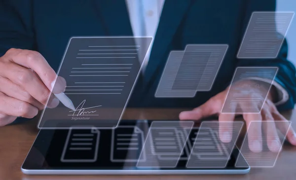 İşadamı elektronik e-imza, veri tablosu belge yönetimi, kağıtsız ofis kavramı için elektronik kalem imzası kullanıyor. Dijital tablette stilus kalem imzalama belgesi kullanan bir işadamı.