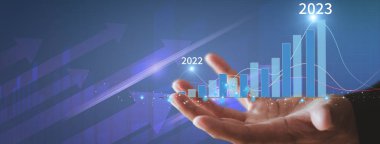 İşadamı, altın borsa bar tablosunun hedefte büyüdüğünü gösterdi. İş finans konsepti. İş adamının elleri başarı grafiğini gösterir, hisse senetleri her yıl çoğalır