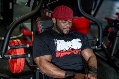 Spor salonunda güçlü kaslı bir adam antrenman yapıyor. Şık atletik erkek, kaslı ve çok çalışıyor..