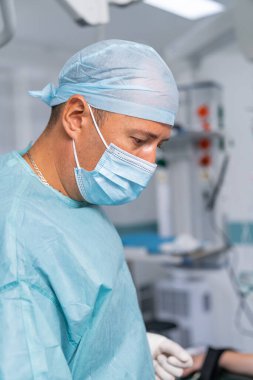 Tıbbi malzemelerle profesyonel cerrahın portresi. Tıbbi maske takan kendine güvenen bir cerrah.