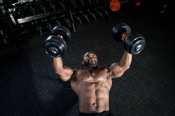 Yakışıklı atletik vücut geliştirici, halterle egzersiz yapıyor. Spor salonunda fitness kaslı çok ırklı adam eğitimi. Fitness konsepti