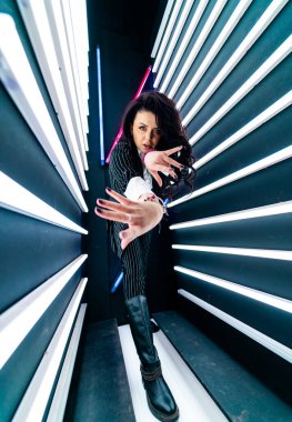 Neon lambaların ışığında güzel bir kadın. Kameraya el uzatan güzel bir kızın portresi. Stok fotoğrafı