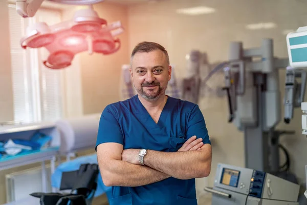 Χειρούργος Στέκεται Αγκαλιά Σταυρωμένα Τον Εξοπλισμό Στο Παρασκήνιο Και Χαμογελώντας — Φωτογραφία Αρχείου