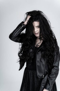 Siyah ceketli kameraya poz veren zarif, güzel bir bayan. Stüdyoda modellik yapan çekici bir genç kız..