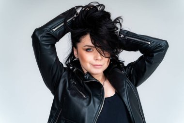 Stüdyoda çekici, zarif bir bayan model. Deri elbiseli güzel bir genç kız fotoshoot 'ta poz veriyor..