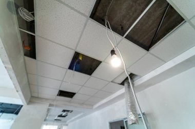 Yönetim binasının tavanında güvenlik ve yangın alarmı var. Tavanın içine inşa edilen lambalar için kare yerler