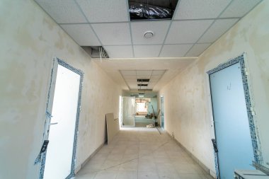Yeni bina yapım aşamasında. Gündüzleri tadilatta uzun bir koridor. Tam uzunluk görünümü