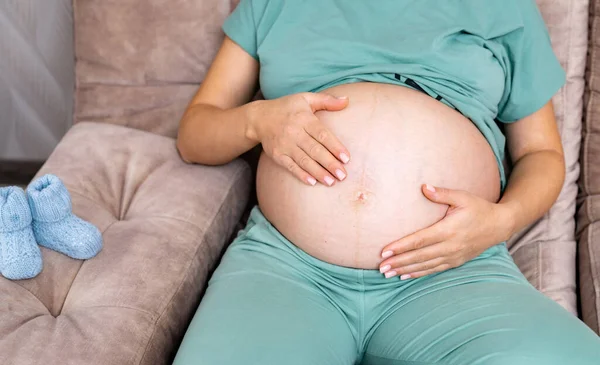 Těhotná Žena Sedí Pohodlné Pohovce Drží Ruce Nahém Břiše Žena — Stock fotografie