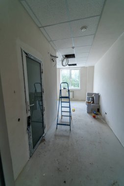 Modern apartman inşaatı. Beyaz duvarlı boş koridor yenilemesi.