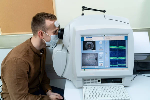 Yetişkin optometrist, insana özel modern ekipman teşhisi koyuyor. Sağlıklı gözler için güncel klinik. Yakın çekim.