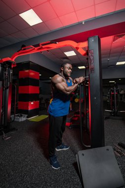 Atletik güçlü adam çalışıyor. Spor salonunda kasları olan güçlü sağlıklı bir adam..