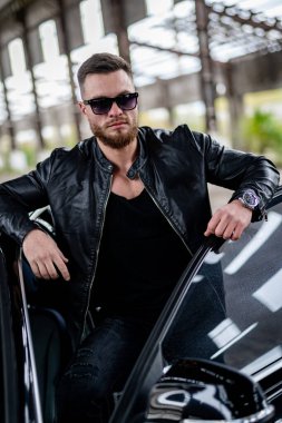 Terk edilmiş şantiyelerin arasında yakışıklı bir adam. Lüks bir hayat. Beyaz düğmesiz gömlekli zengin adam. Erkek görünümü konsepti