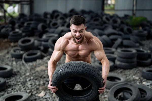 Starker Junger Mann Hebt Reifen Hemdlos Große Muskeln Und Perfekte — Stockfoto