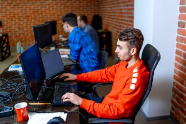 Genç programcı işyerinde oturuyor ve kod yazıyor. Girişim işi. Program geliştirme konsepti. Kodlama teknolojileri