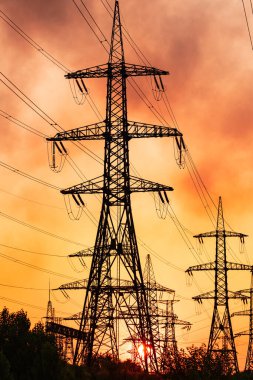 Enerji iletim kulelerinin gölgeleri. Yüksek voltajlı kule silueti gün batımı.