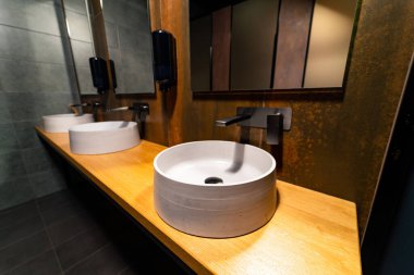 Siyah banyonun içi beyaz lavaboyla dolu. Lüks banyo iç çamaşırları..