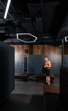 Eğitimini tamamlarken jimnastik soyunma odasında duran formda genç adam. Motivasyonlu spor yaşam tarzı konsepti