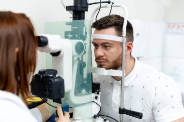 Optometrist hasta gözlerini kontrol ediyor. Modern hastanede klinik uzmanı vizyonu inceliyor..