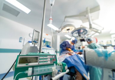 Ameliyat ekipmanlarıyla birlikte bir grup beyin cerrahı ameliyathanede. Doktorlar yüksek teknolojili ekipman kullanıyorlar. Modern tıbbi geçmiş.