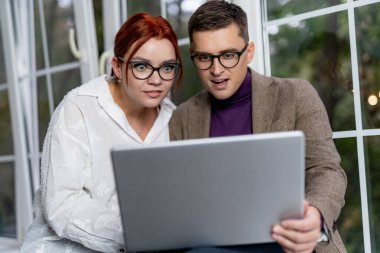 Dışarıda dizüstü bilgisayar kullanan serbest çalışanlar. Yakışıklı bir erkek ve güzel bir kadının portresi. Meslektaşlar proje üzerinde çalışıyor. Başarılı bir iş. Video konferansı.