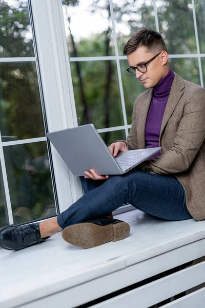 Snygg Affärsman Som Sitter Vid Fönsterbrädan Och Jobbar Laptopen Ung — Stockfoto