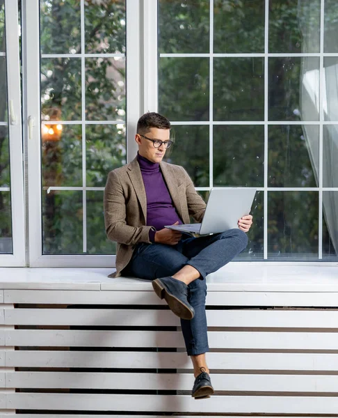 정장을 화면을 있습니다 창턱에 앉아서 노트북에서 일하는 솜씨좋은 사업가 — 스톡 사진