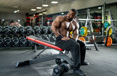Spor salonunda poz veren çıplak vücut kas geliştirici. Güçlü kaslı vücudu olan güçlü bir atletik..