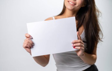 Boş afişi olan güzel bir model. Beyaz kağıt gösteren genç bayan..