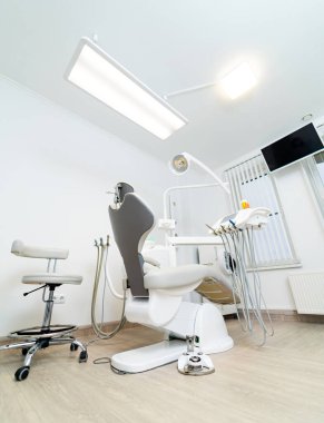 Klinik stomatoloji odası. Modern beyaz dişçilik dolabı.