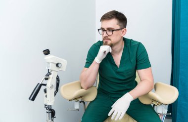 Üniformalı profesyonel tıp çalışanı. Gözlüklü ciddi bir erkek doktor..