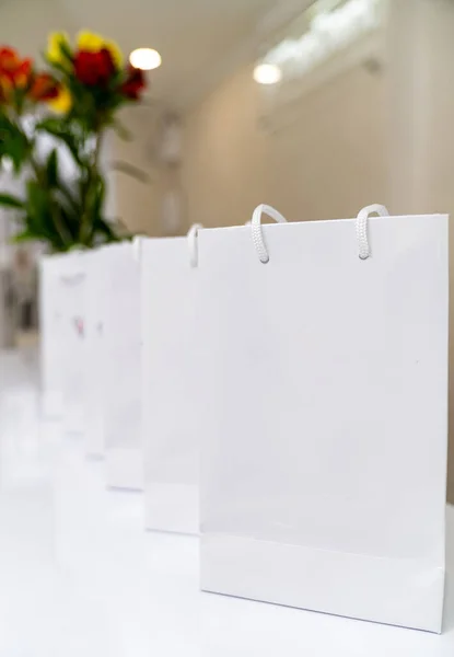 Paper white bags for shopping. Cardboard gift packets.