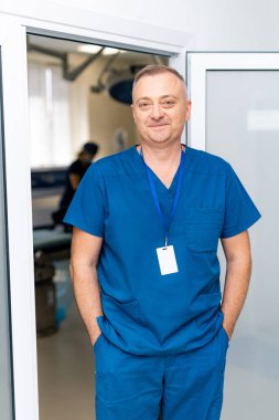 Doctor with badge in hospital hall. Confident young male specialist.