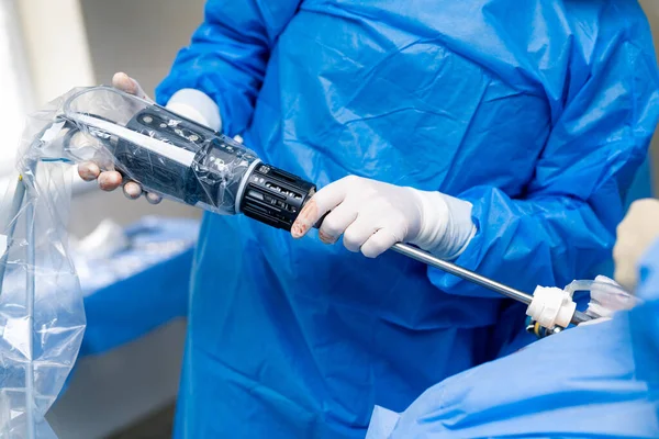Surgeon in mask with sterile instruments. Surgery specialist working with new technologies.