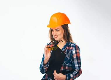 Attractive woman worker in hardhat. Young female builder in glasses and helmet.