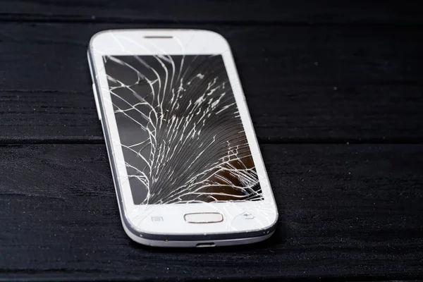 Phone with broken screen. Digital white smartphone with smashed screen.