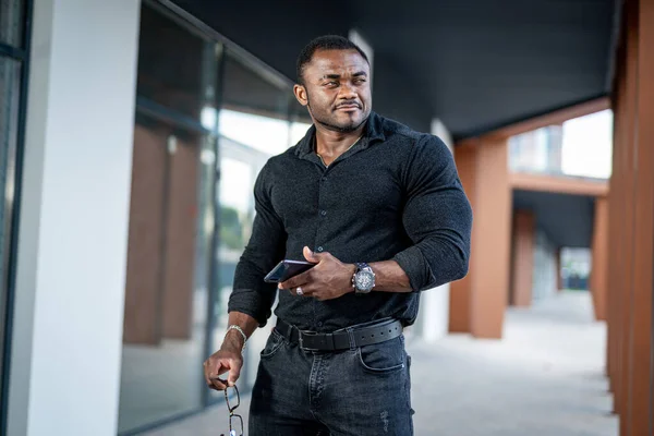 Portrait of young man in black shirt. Fahionable elegant male model in darl casual cloth.