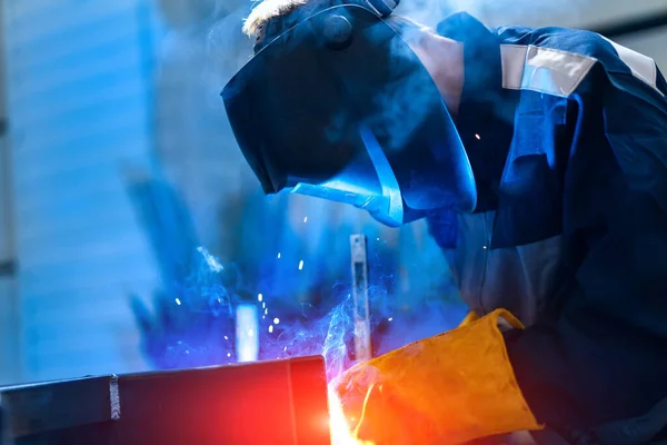 Man in protective helmet working with heavy metal construction. Professional engineering in uniform.