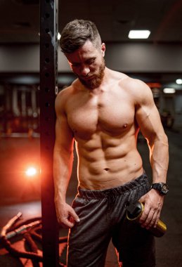 Tişörtsüz bir vücut geliştirme ustası. Atletik vücudu olan güçlü kaslı bir adam..