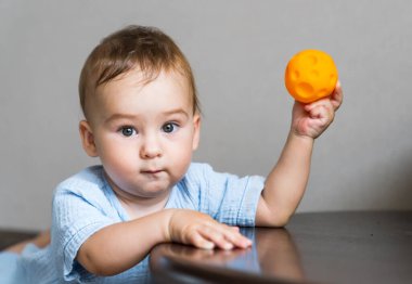 Elinde küçük bir topla küçük sevimli bir çocuk. Renkli topları olan neşeli genç bir çocuk..