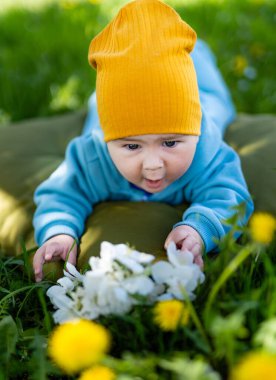 Neşeli şirin çocuk bahçesi eğleniyor. Yeşil çimlerin üzerinde güzel bir çocuk.