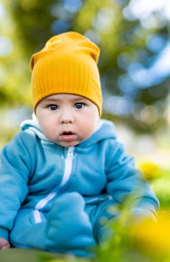 Yeşil çimlerin üzerinde güzel bir çocuk. Neşeli şirin çocuk bahçesi eğleniyor.