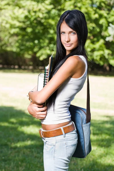 Aantrekkelijke jonge brunette student buitenshuis. — Stockfoto