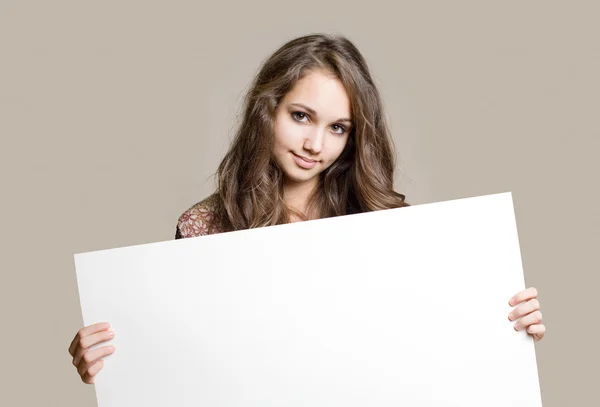 Gorgeous young brunette teen with blank sign. Stock Photo