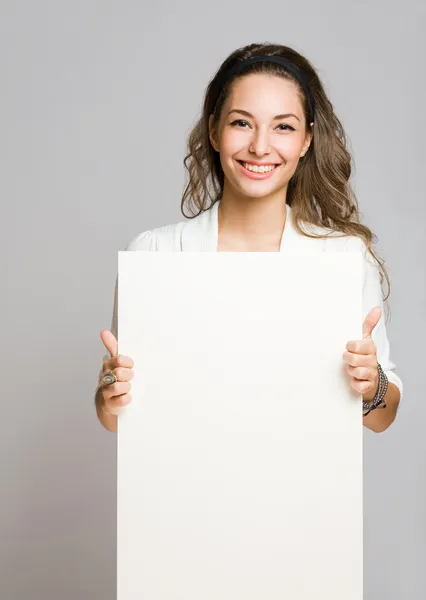 Chherful young brunette with blank banner. Royalty Free Stock Images