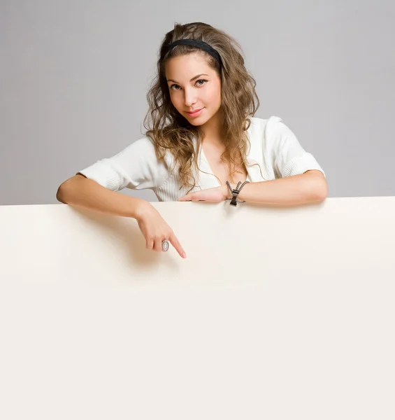 Young brunette woman with blank sign. — Stock Photo, Image