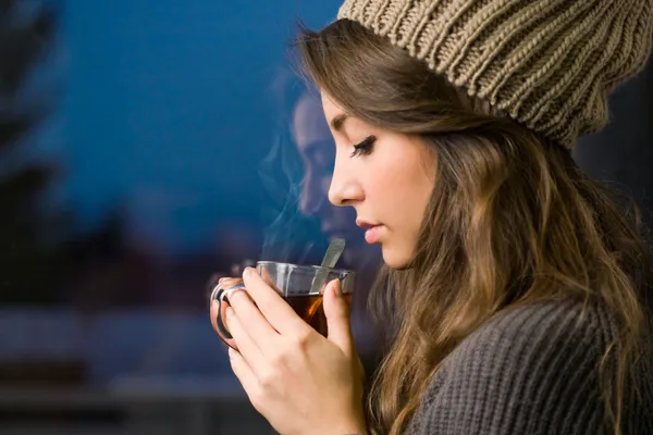 Young brunette with hot tea. — Stock Photo, Image