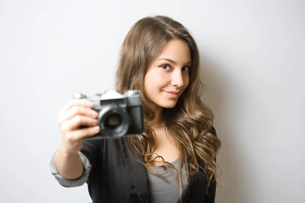 Brunette schoonheid bedrijf vintage camera. — Stockfoto