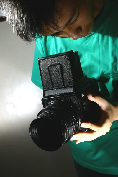Pessoa ou adolescente olhando através de uma câmera de filme de médio formato — Fotografia de Stock