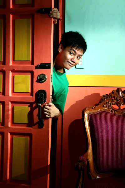 Jonge Aziatische tiener gluren en sluipen in een woonkamer — Stockfoto